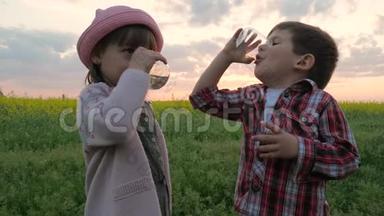 小可爱的孩子，男孩和女孩喝水，孩子们解渴，孩子`在日落时用手拿着玻璃干净的纯<strong>净水</strong>